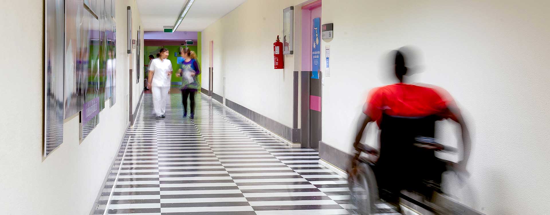 senhor em cadeira de rodas num corredor do hospital