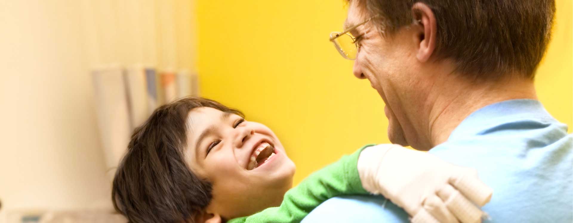 senhor com criança sorridente ao colo