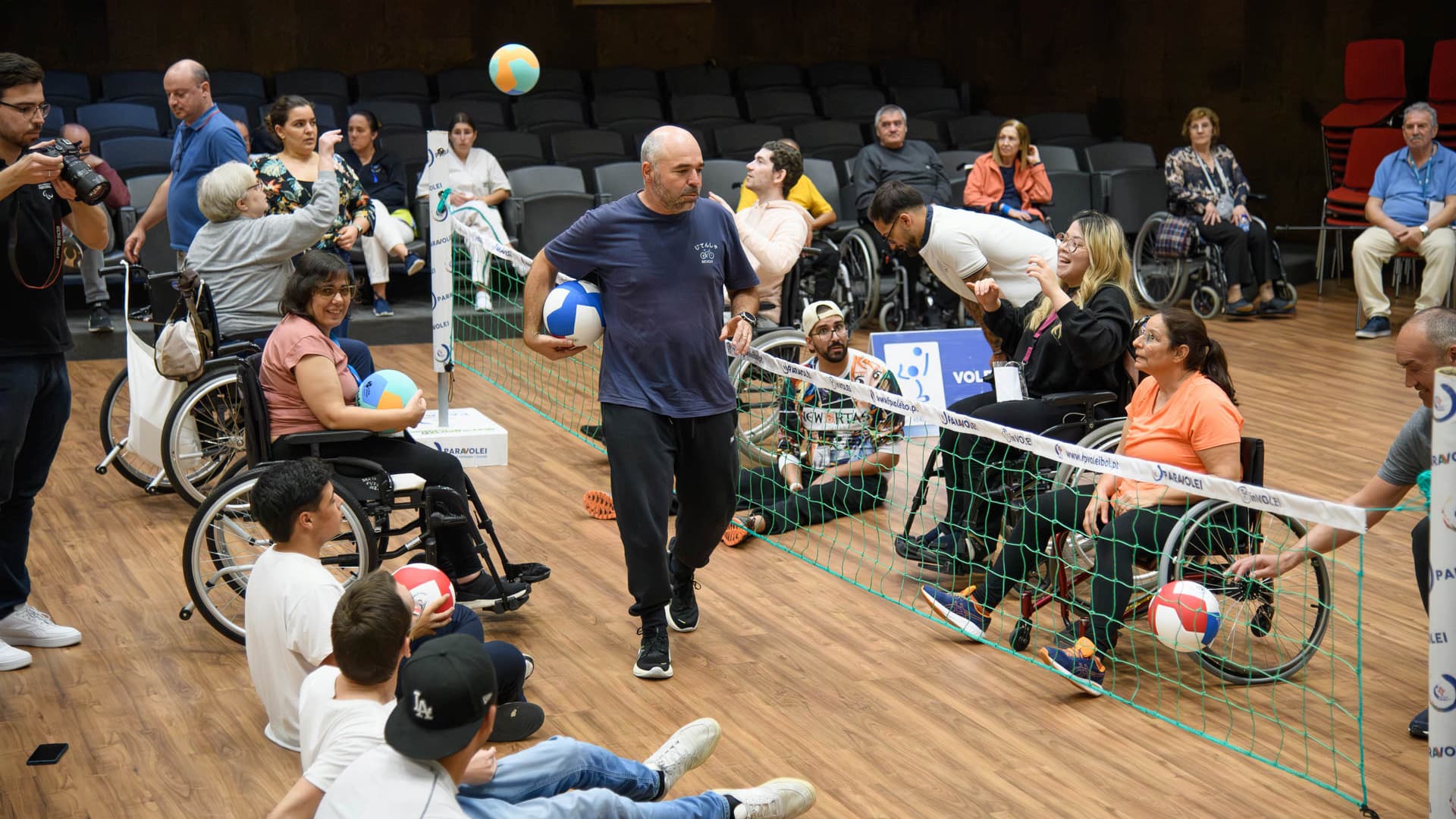 utentes e profissionais em sessão de voleibol adaptado no auditório do Centro de Medicina de Reabilitação de Alcoitão