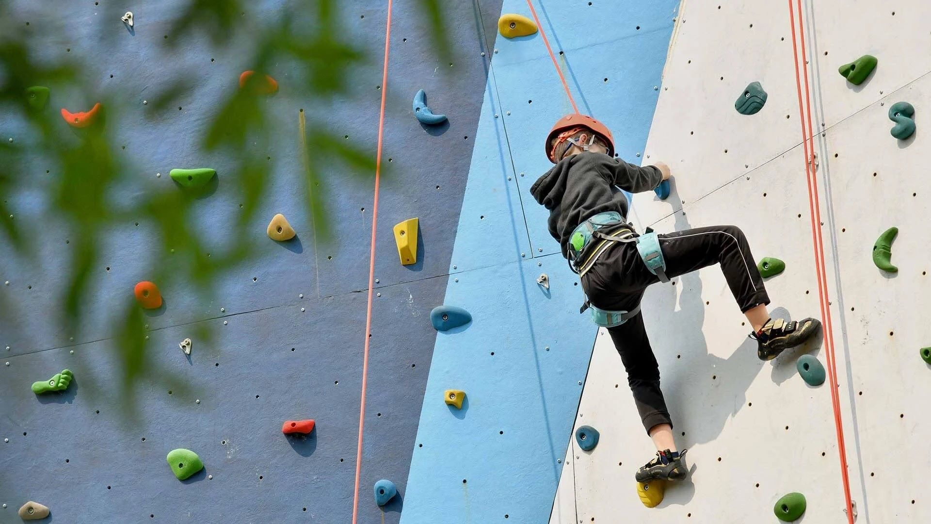 Jovem a escalar parede de escalada